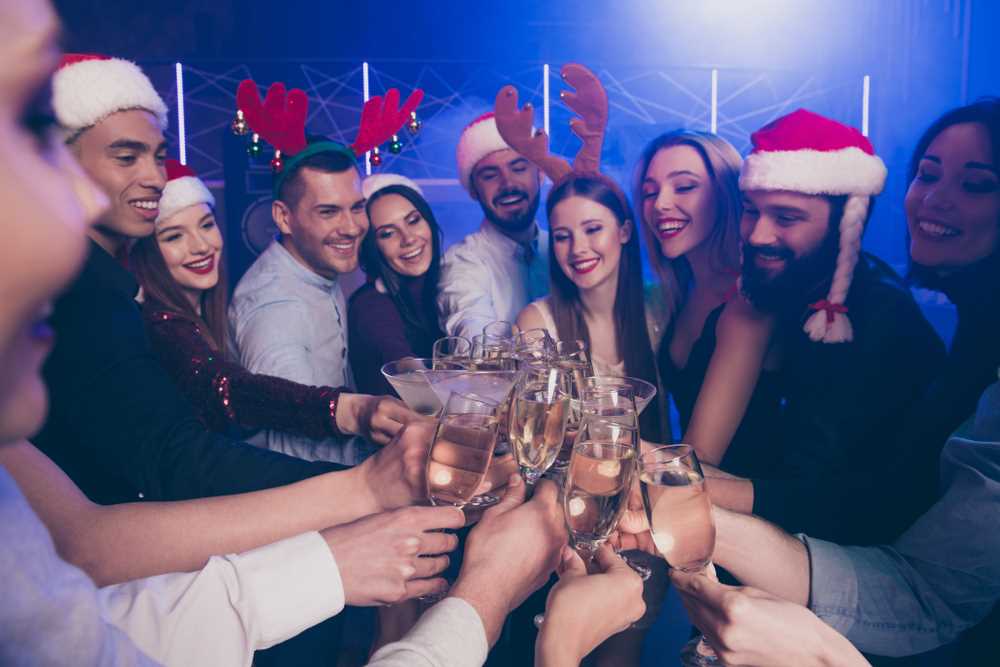 Nice attractive cheerful cheery positive funky girls and guys having fun rest relax clinking wineglass congrats amusement winter feast in luxury place nightclub indoors