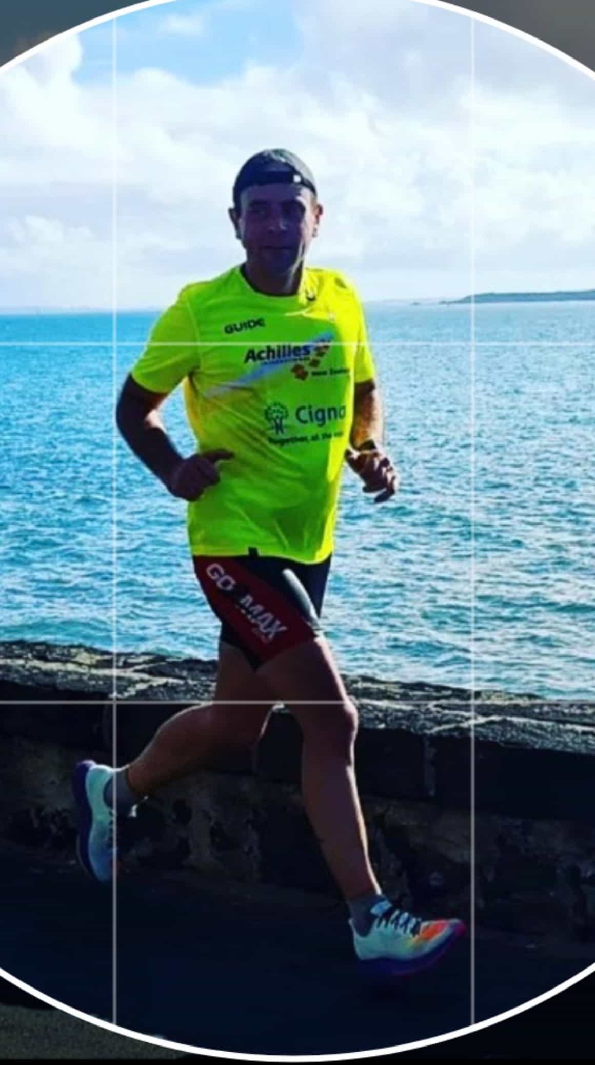 David Thompson running in Achilles t-shirt along the water front