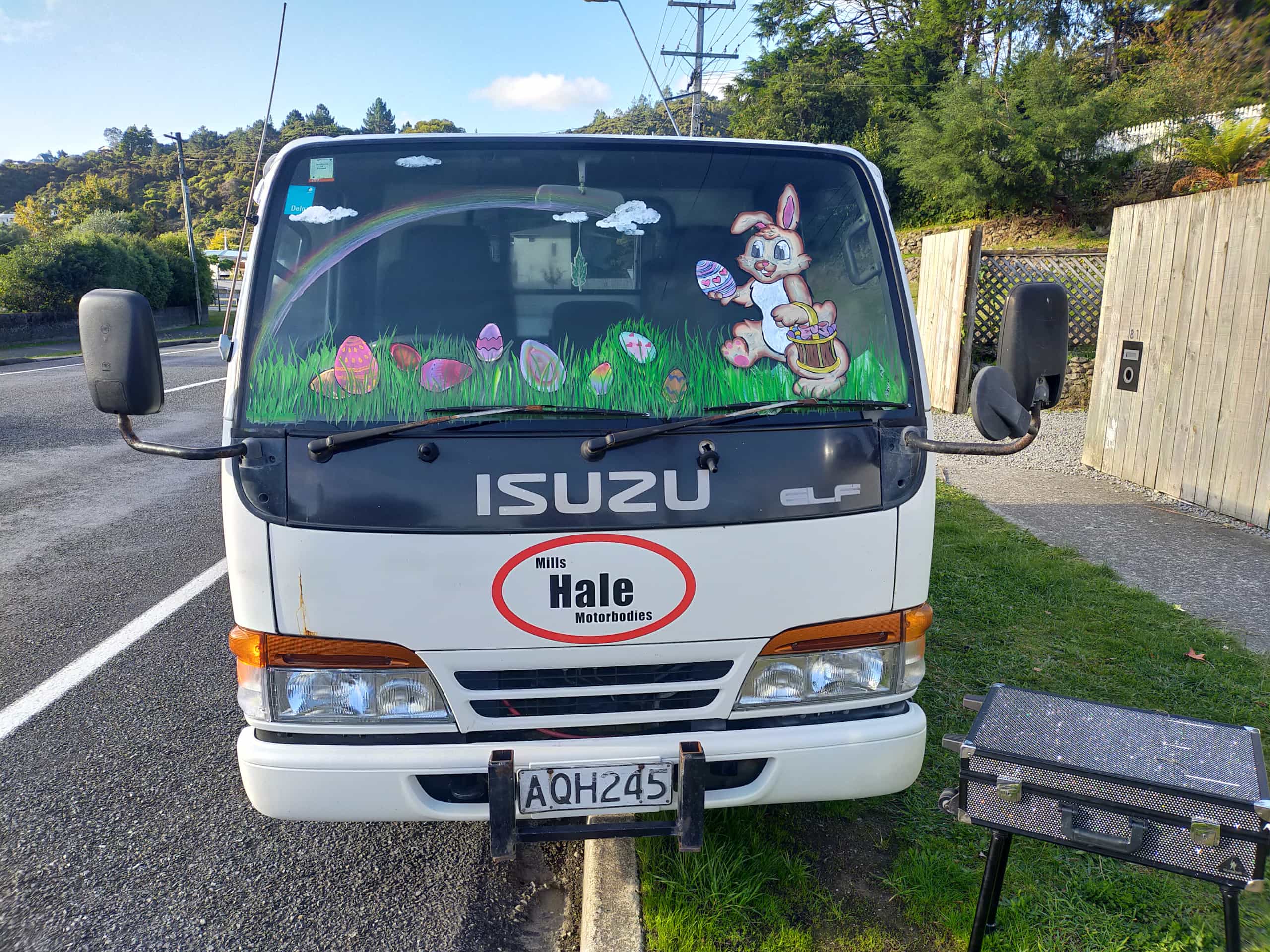 A white Isuzu truck with an Easter bunny, delivering brightly coloured eggs painted across the windscreen. 