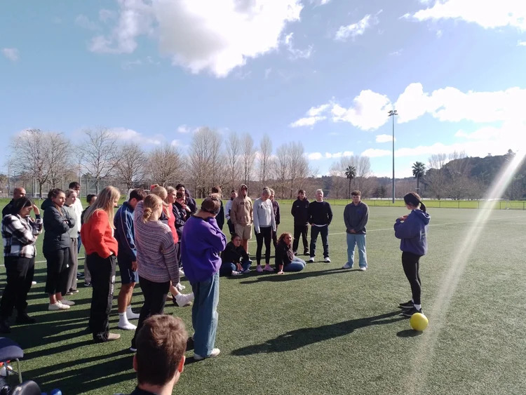 A group of people outside on a field doing Harbour Sports Training