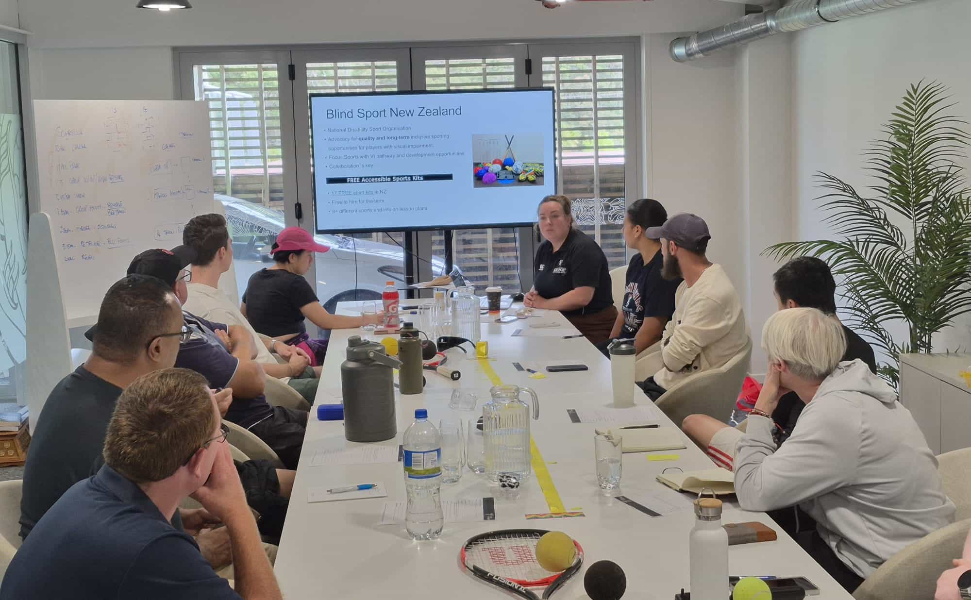 Chelsea delivering training in Tennis NZ board room to a group of Tennis NZ coaches around a table. 