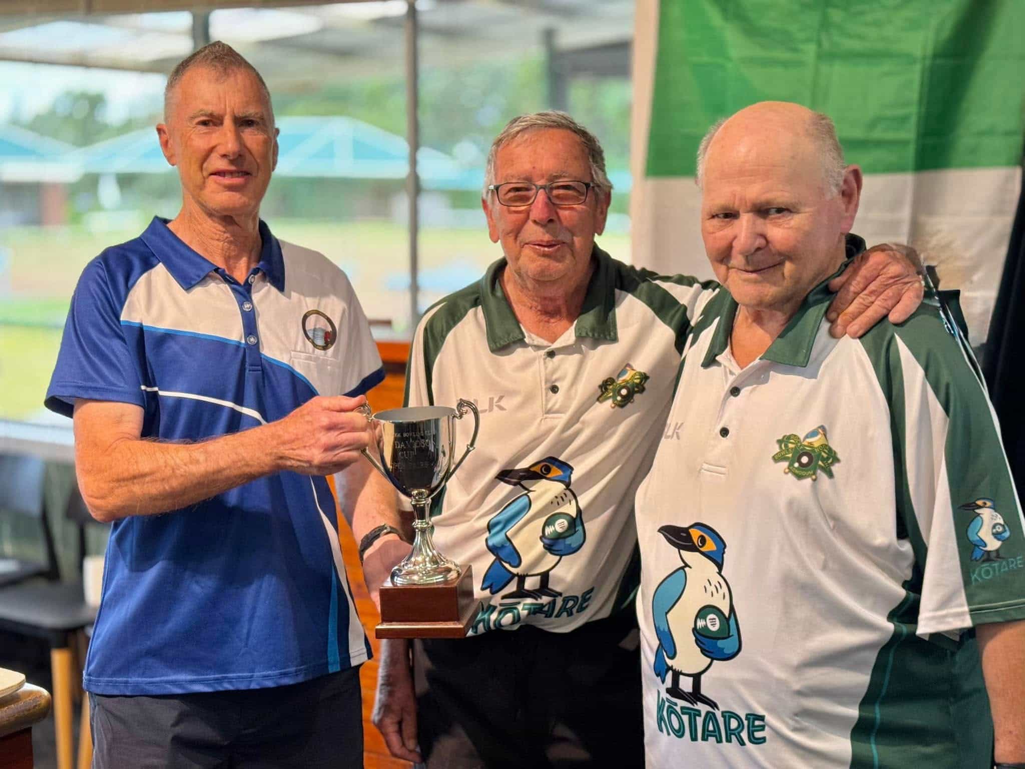 Sean Carroll and Colin Marychurch being presented with the winners' trophy by Len's son, Murray.
